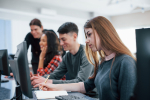 Concentrated blonde. Group of young people in casual clothes working in the modern office