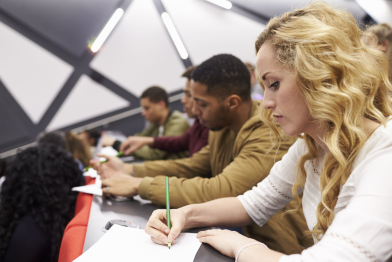 female-student-taking-notes-university-lecture-theatre