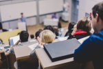 Professor giving presentation in lecture hall at university.