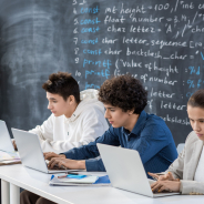 row-three-contemporary-serious-students-co-working-front-laptops-while-sitting-by-desk