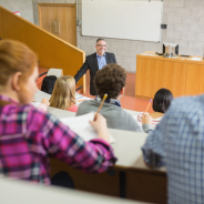 Elegant teacher with students sitting at the college lecture hall