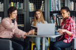 three-happy-students-writing-notebooks-laptop-library (1)