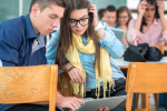 Two classmates using laptop together