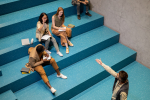 Young teacher pointing at student with raised hand